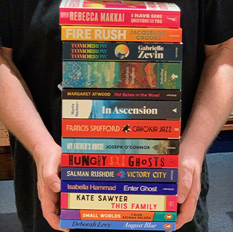 A pile of books in someones hands